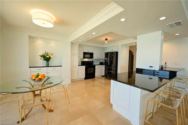 a large kitchen with stainless steel appliances granite countertop a sink and a refrigerator