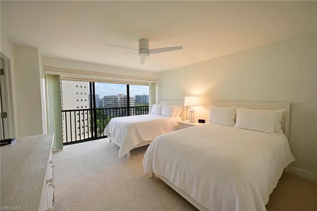 a bed room with two beds and a large window