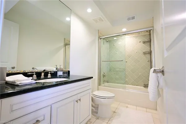 a bathroom with a double vanity sink toilet and shower