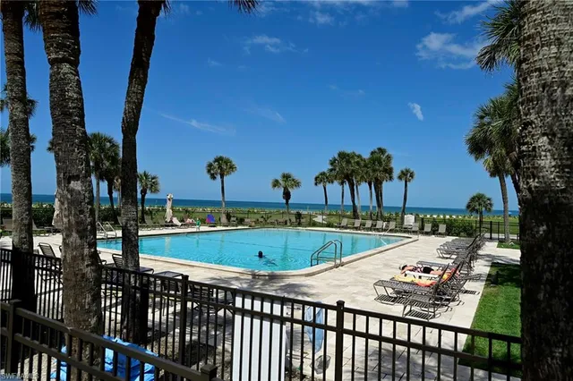 a view of a swimming pool with a patio and fire pit
