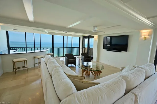 a living room with furniture a large window and a flat screen tv