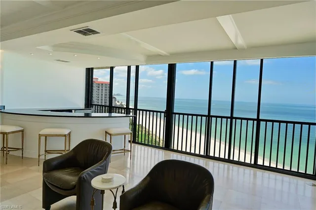 a living room with furniture and a floor to ceiling window