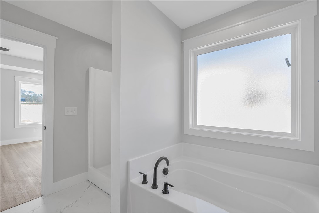 2812 Smith McGee Road Iva, SC 29655 - Photo 21 of 26 This primary bathroom features a deep soaking tub, a shower, and a large window.