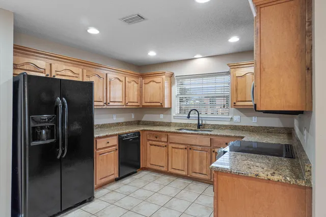 a kitchen with a sink a refrigerator and cabinets