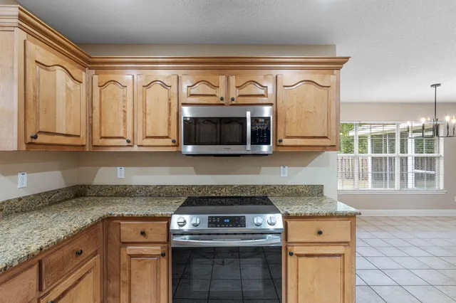 a kitchen with granite countertop a stove and a sink