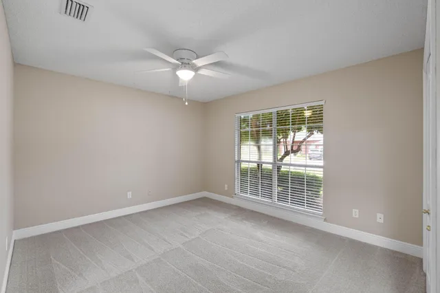 an empty room with chandelier fan
