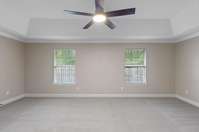 an empty room with a window and a fan