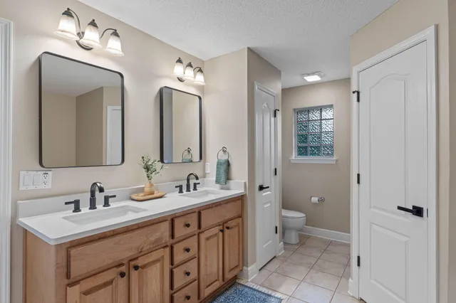 a spacious bathroom with a double vanity sink mirror and toilet