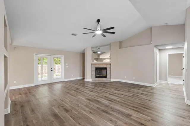 a view of a livingroom with a ceiling fan window and wooden floor
