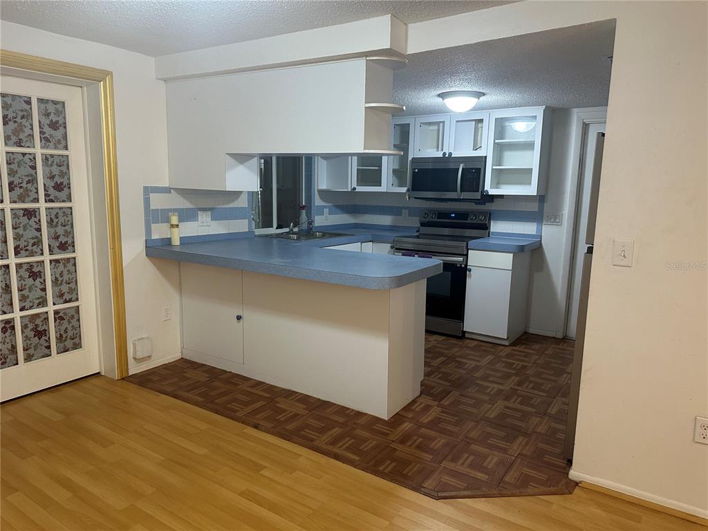 9741 Scenic Drive Port Richey, FL 34668 - Photo 5 of 17 a kitchen with stainless steel appliances granite countertop a sink stove and cabinets