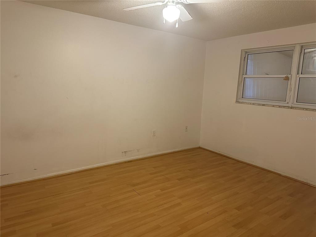 9741 Scenic Drive Port Richey, FL 34668 - Photo 10 of 17 an empty room with a chandelier fan