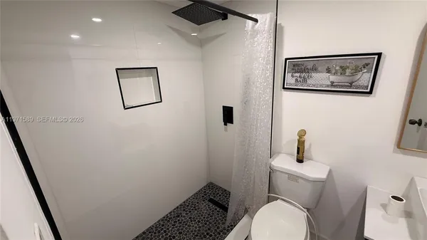 a white toilet sitting next to a bathroom sink and vanity