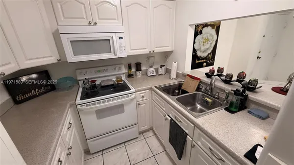 a kitchen with a sink a stove and cabinets