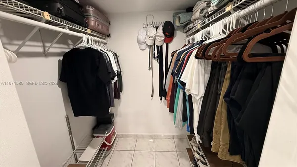a view of walk in closet with clothes and shoes