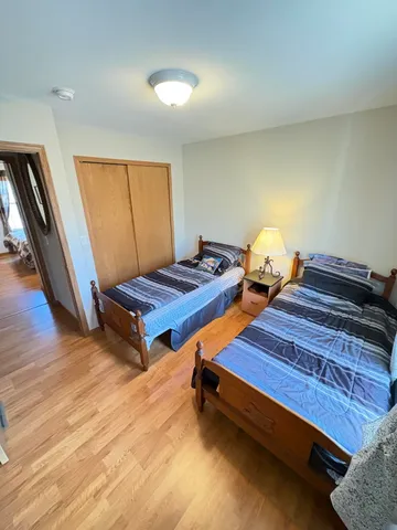 a bedroom with two beds and wooden floor