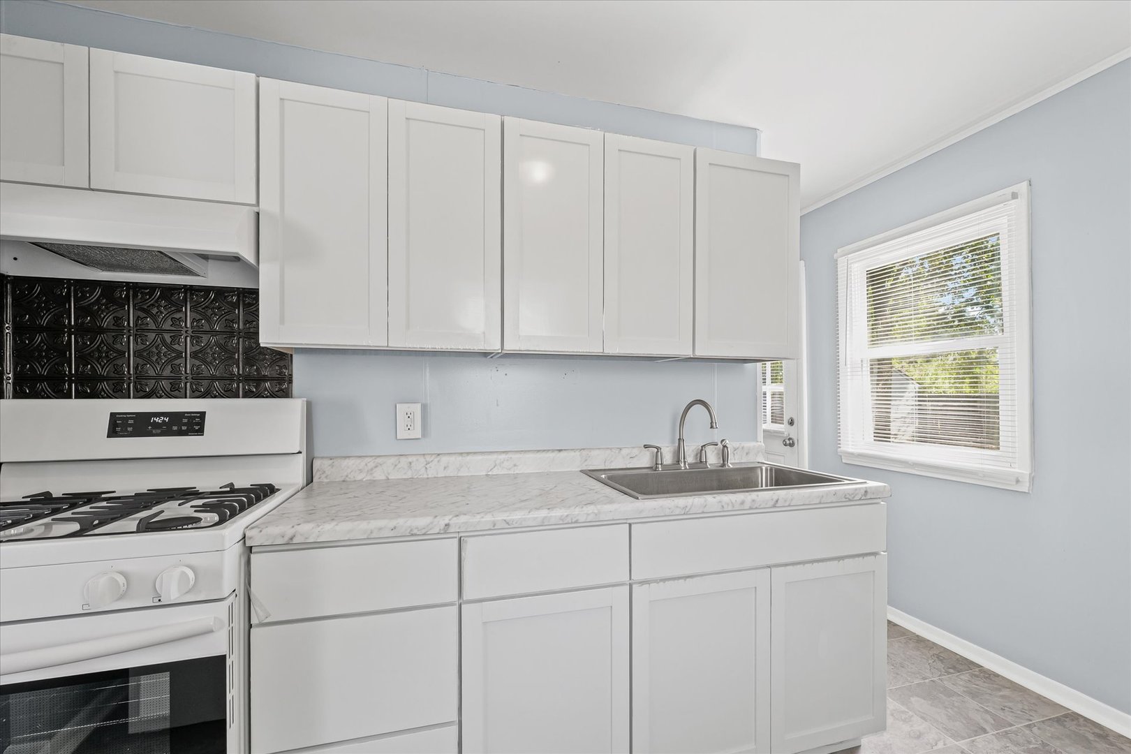 1116 Bel Aire Drive Rantoul, IL 61866 - Photo 12 of 27 a kitchen with granite countertop a sink stove top oven and cabinets