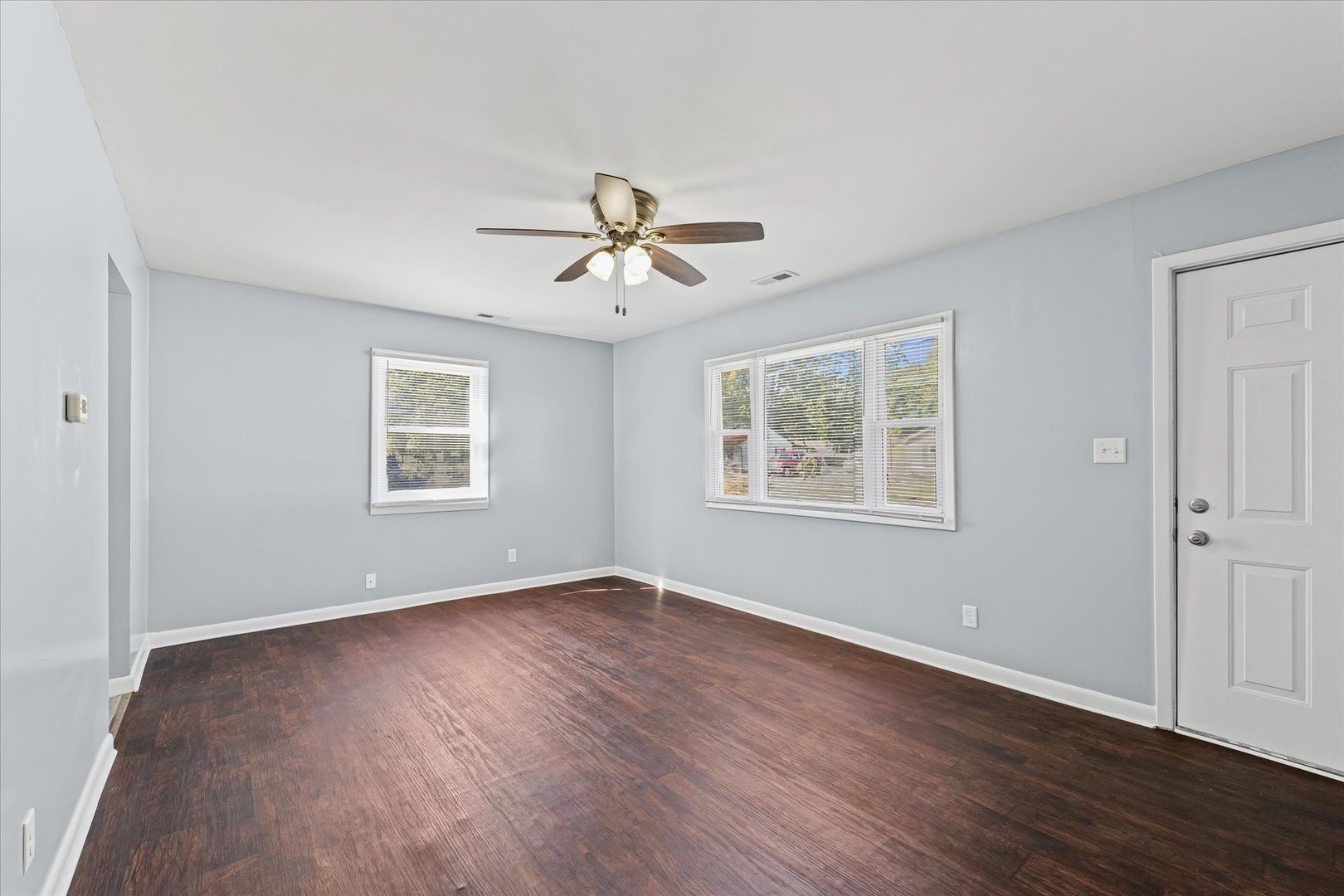 1116 Bel Aire Drive Rantoul, IL 61866 - Photo 6 of 27 a view of an empty room with a window and wooden floor