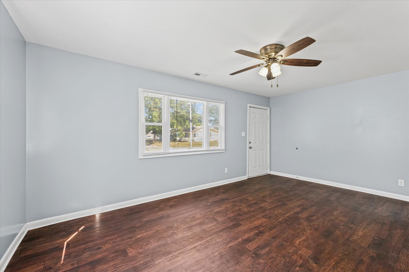 1116 Bel Aire Drive Rantoul, IL 61866 - Photo 8 of 27 a view of empty room with wooden floor and fan