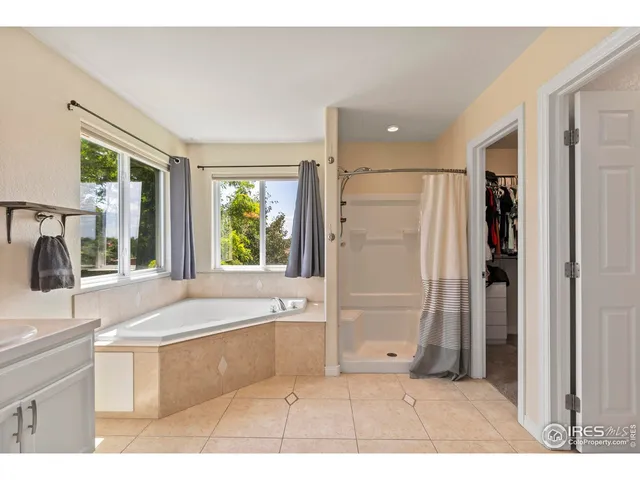 a bathroom with a tub a sink and a large mirror