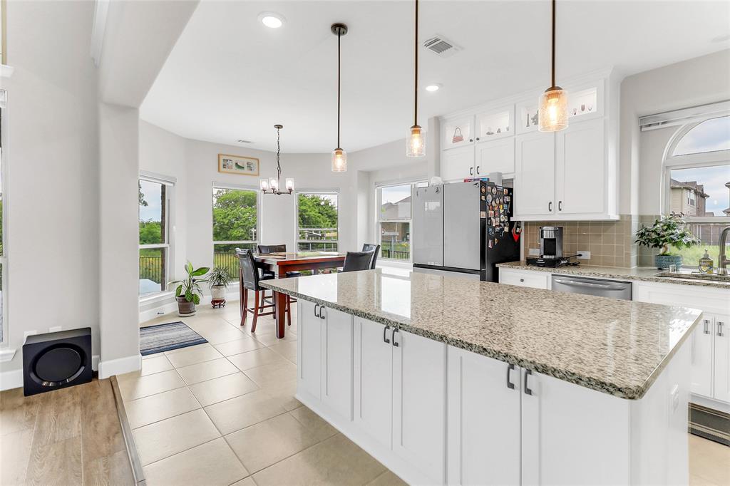 3425 Cotton Mill Road Celina, TX 75009 - Photo 26 of 40 a kitchen with stainless steel appliances granite countertop a sink a stove and a wooden floors