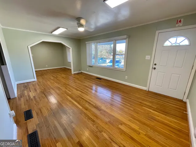 an empty room with wooden floor and windows