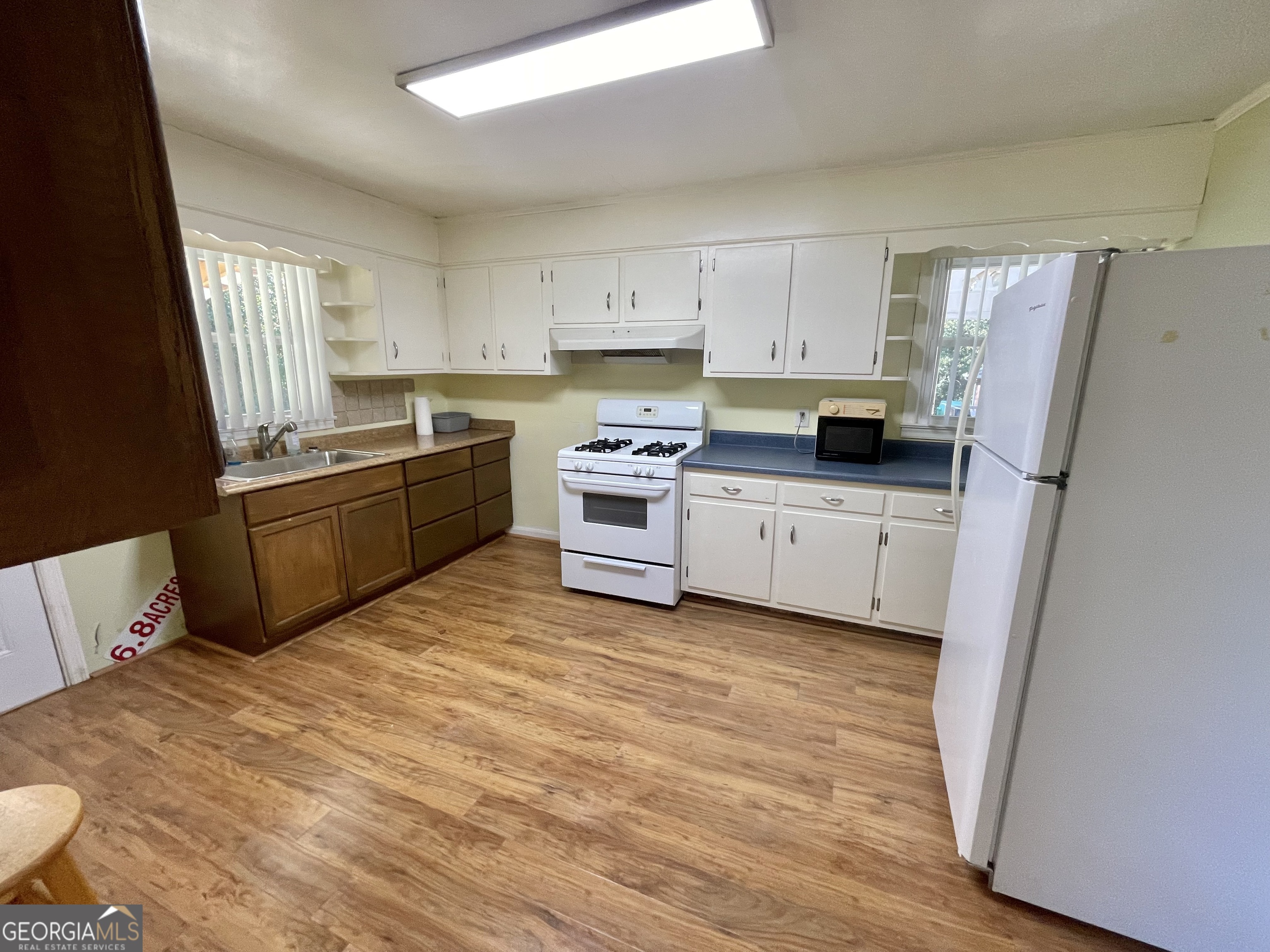 220 Airport Road Griffin, GA 30223 - Photo 6 of 23 a kitchen with stainless steel appliances a stove a sink a refrigerator a window