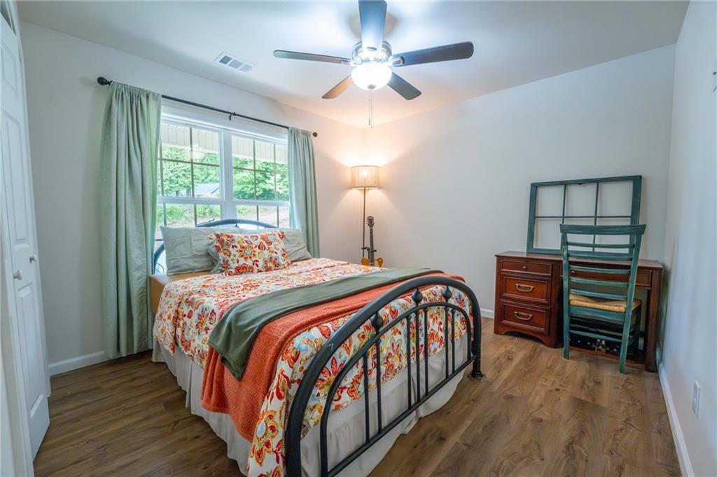 118 Wash Rider Road Dahlonega, GA 30533 - Photo 13 of 37 a bedroom with a bed and a chandelier