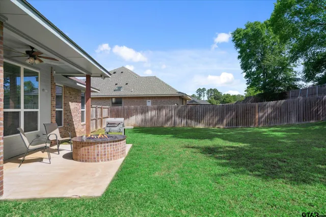 a view of a house with backyard and sitting area