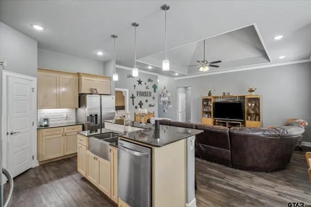 a kitchen with stainless steel appliances granite countertop a sink a stove and a refrigerator