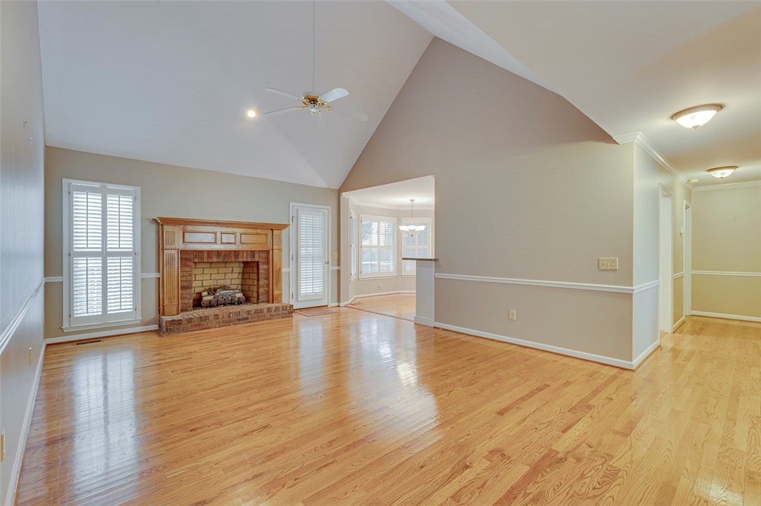 302 Wild Rice Drive Simpsonville, SC 29681 - Photo 4 of 44 Polished hardwood floors and a brick fireplace define this inviting living space with vaulted ceilings.