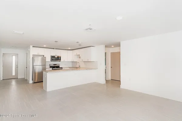 a view of a kitchen with refrigerator and microwave