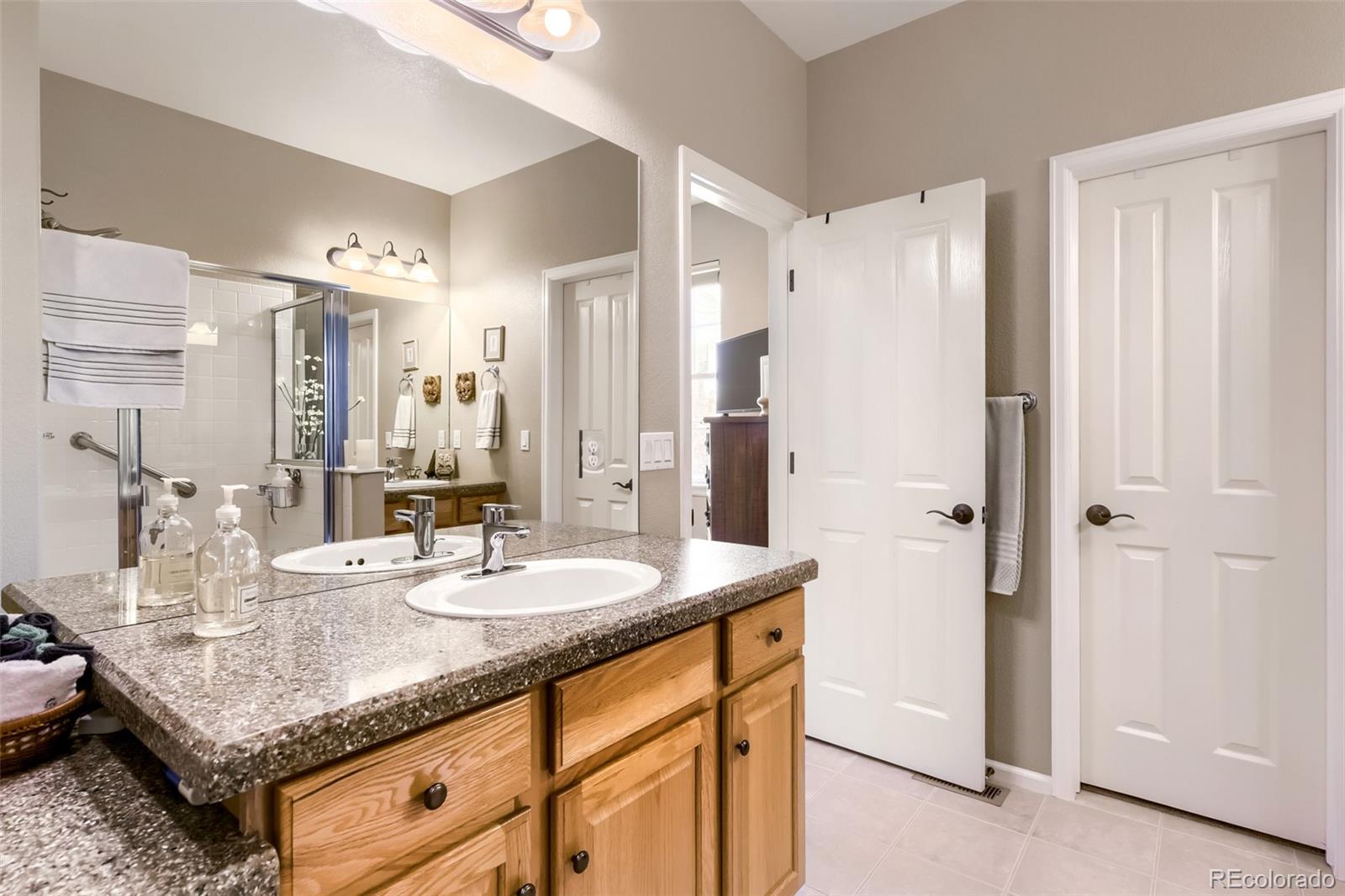 9006 Old Tom Morris Circle Highlands Ranch, CO 80129 - Photo 16 of 41 a bathroom with a granite countertop sink and a mirror