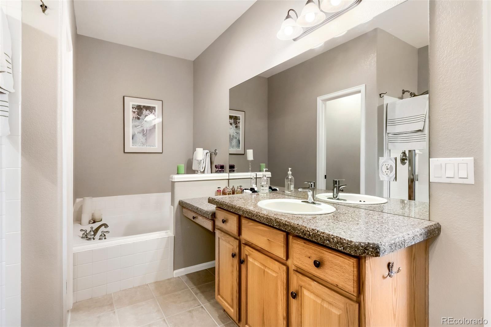 9006 Old Tom Morris Circle Highlands Ranch, CO 80129 - Photo 17 of 41 a bathroom with a granite countertop sink and a mirror