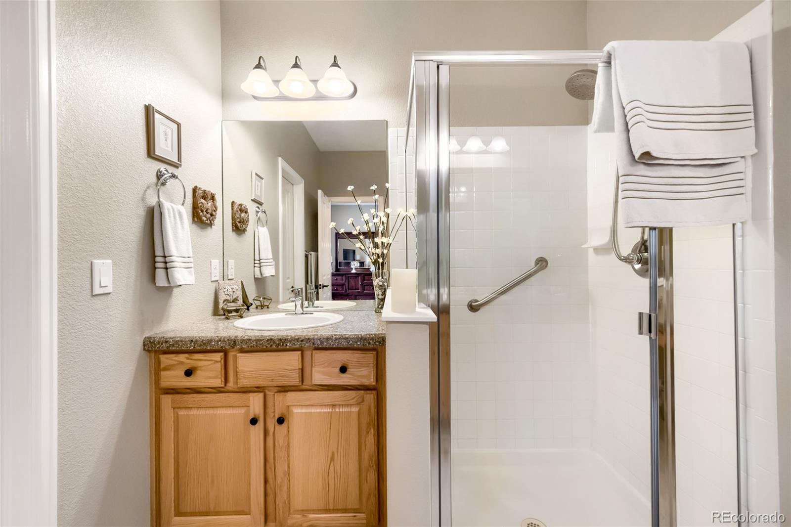 9006 Old Tom Morris Circle Highlands Ranch, CO 80129 - Photo 18 of 41 a bathroom with a sink vanity mirror and shower