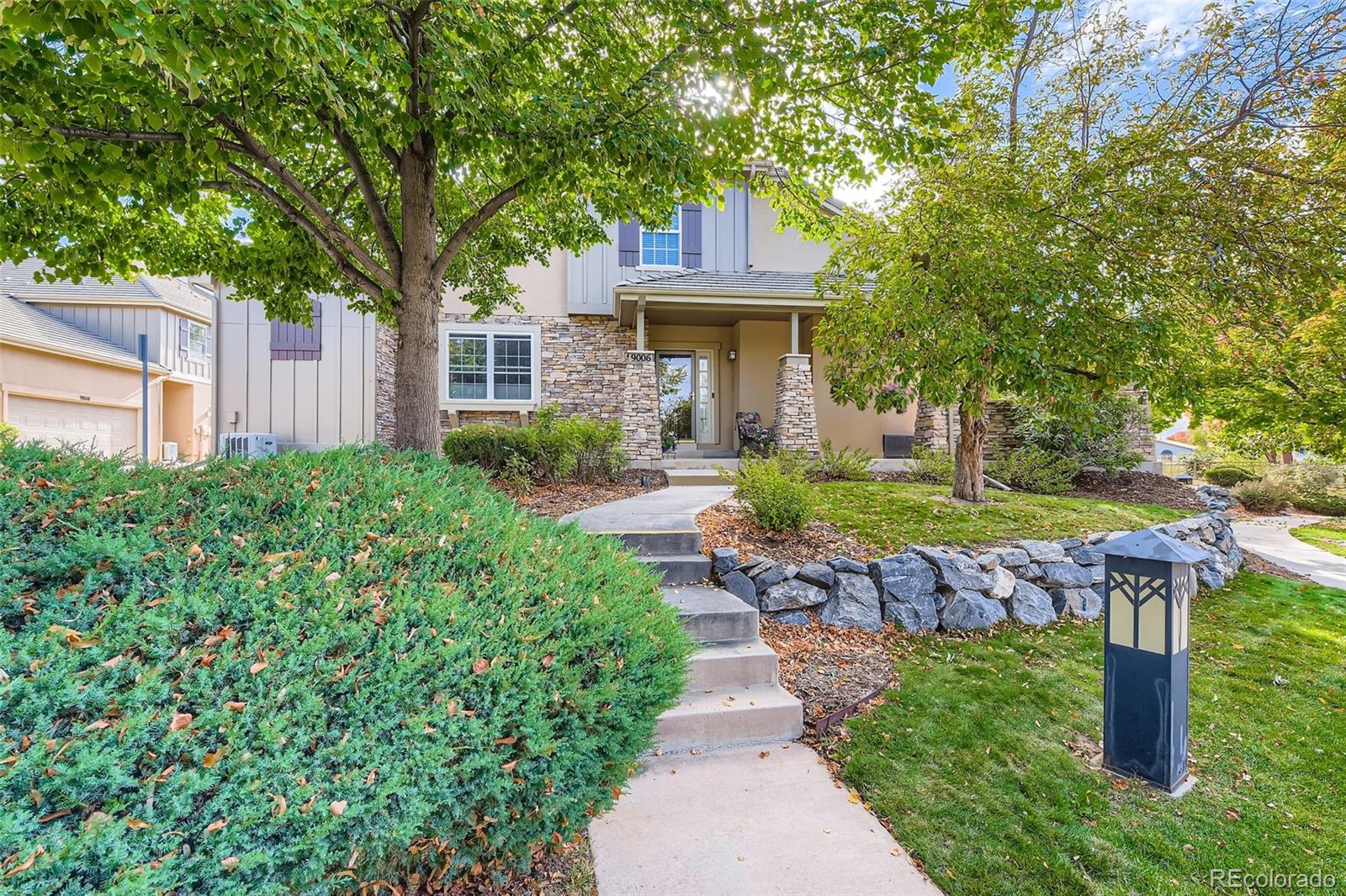 9006 Old Tom Morris Circle Highlands Ranch, CO 80129 - Photo 31 of 41 a front view of a house with a yard and shrubs