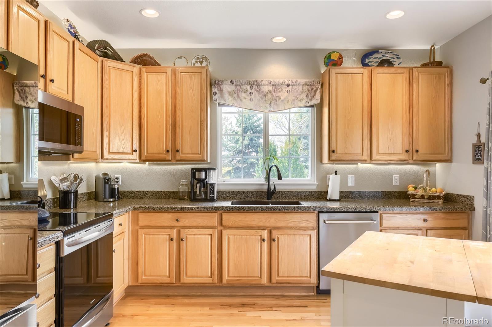 9006 Old Tom Morris Circle Highlands Ranch, CO 80129 - Photo 10 of 41 a kitchen with stainless steel appliances granite countertop a sink a stove a counter space and cabinets