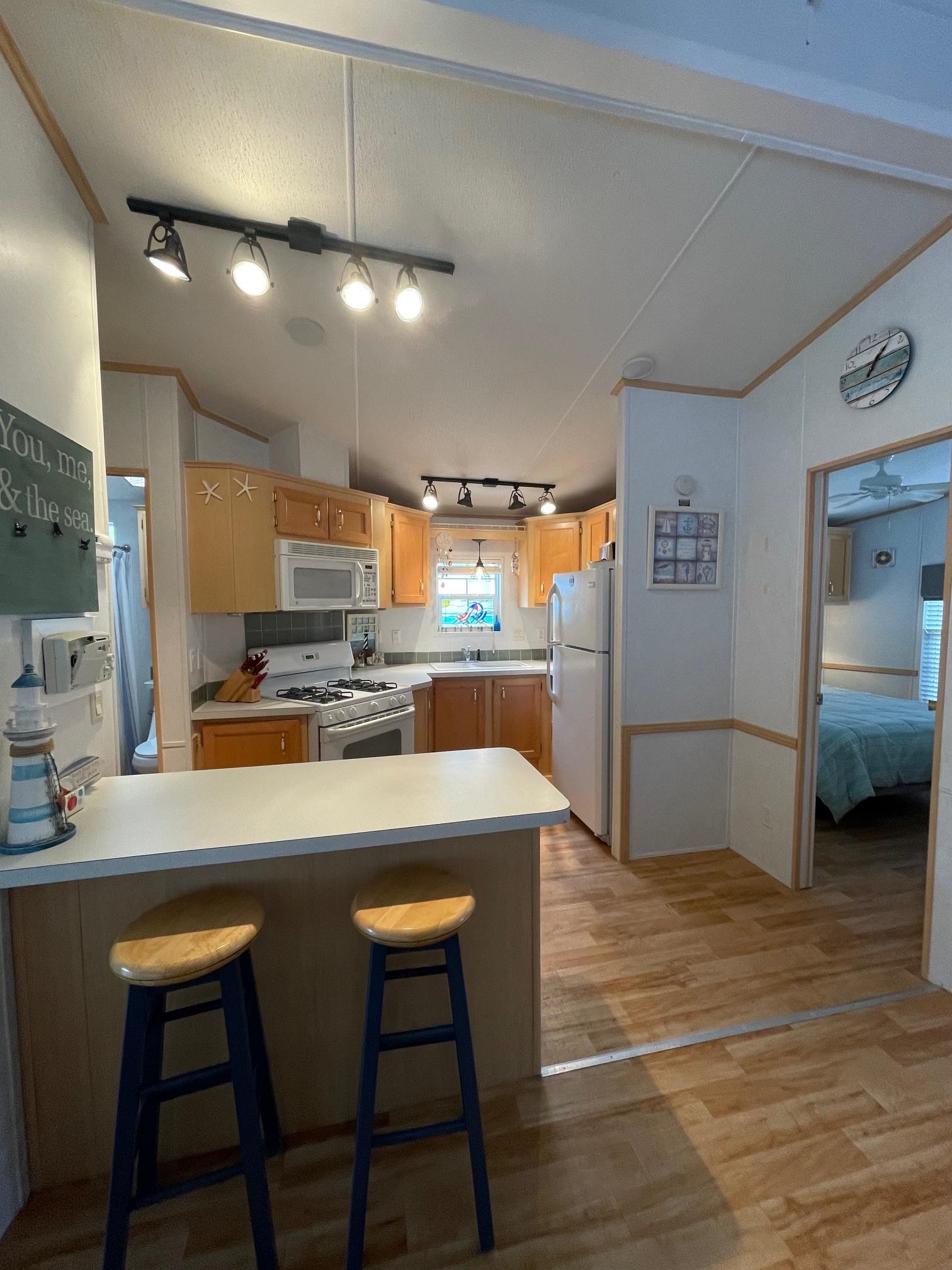 4100 Rte 9 South, Unit 9 Rio Grande, NJ 08242 - Photo 14 of 31 a kitchen with kitchen island a stove a table and chairs in it