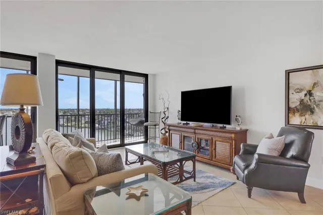 a living room with furniture flat screen tv and a large window