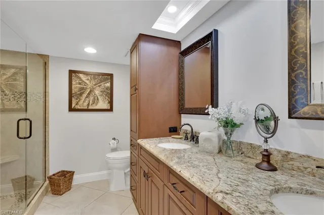 a bathroom with a granite countertop toilet sink and mirror