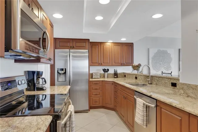 a kitchen with stainless steel appliances granite countertop a sink refrigerator and cabinets