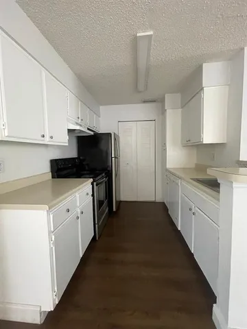a kitchen with granite countertop white cabinets and stainless steel appliances