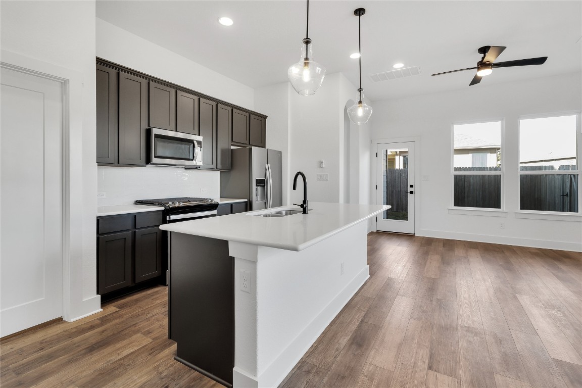 8589 Meridy Loop Round Rock, TX 78665 - Photo 12 of 36 a kitchen with stainless steel appliances kitchen island a refrigerator sink and microwave