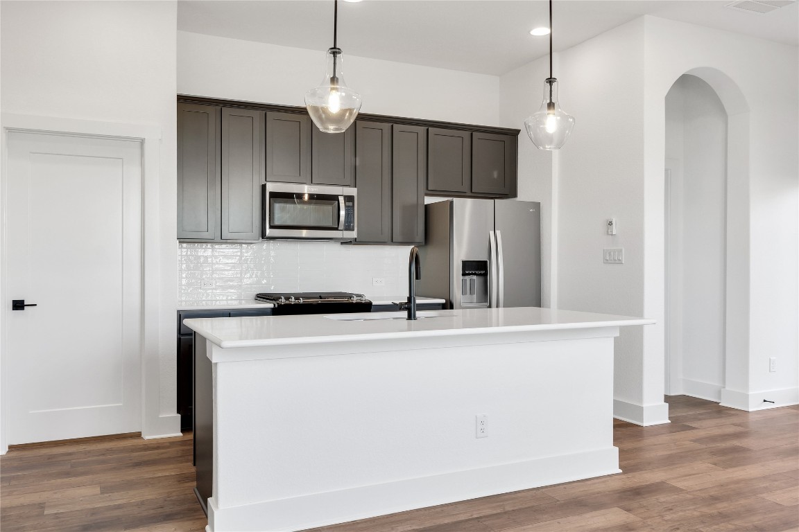8589 Meridy Loop Round Rock, TX 78665 - Photo 13 of 36 a kitchen with stainless steel appliances a stove a refrigerator a sink and a microwave