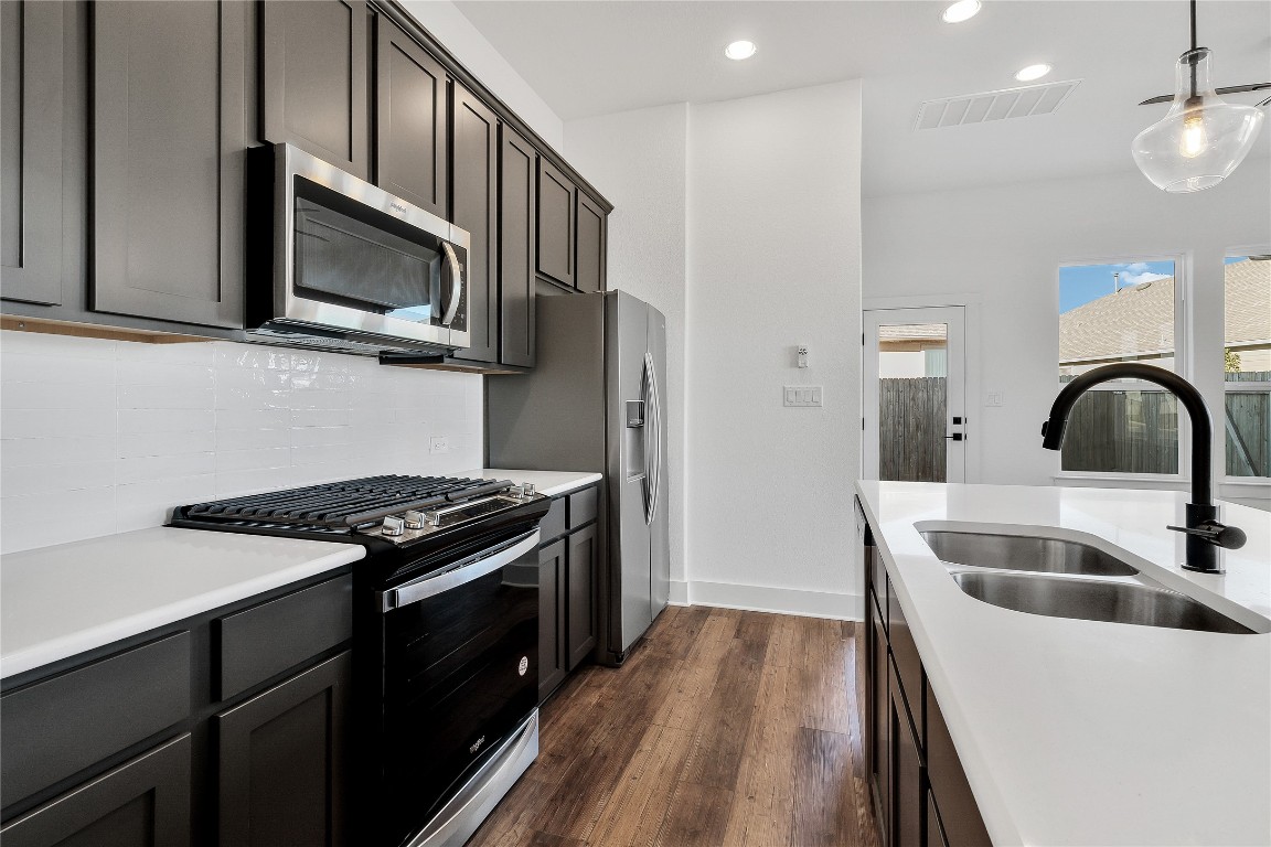 8589 Meridy Loop Round Rock, TX 78665 - Photo 15 of 36 a kitchen with stainless steel appliances granite countertop a stove a sink and a microwave