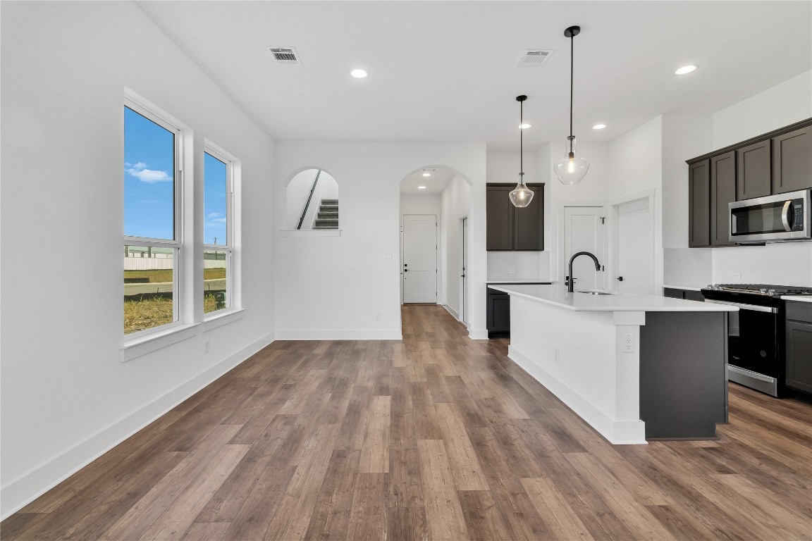 8589 Meridy Loop Round Rock, TX 78665 - Photo 17 of 36 a large kitchen with stainless steel appliances kitchen island a large counter top and a wooden floors