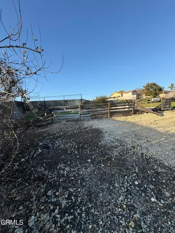 a view of a yard with wooden fence