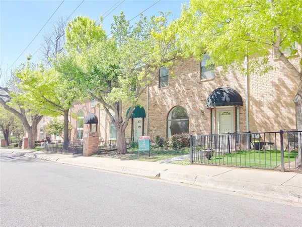 a view of a house with a yard and potted plants