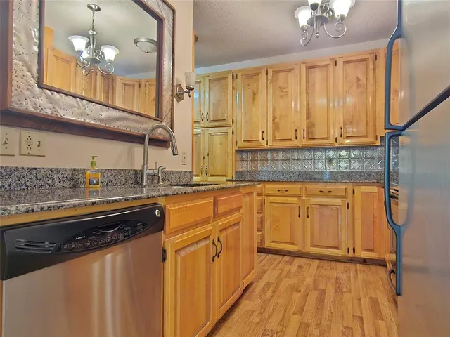 a kitchen with stainless steel appliances granite countertop a sink and cabinets