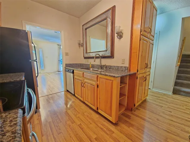 a kitchen with stainless steel appliances granite countertop a sink a stove a refrigerator and cabinets