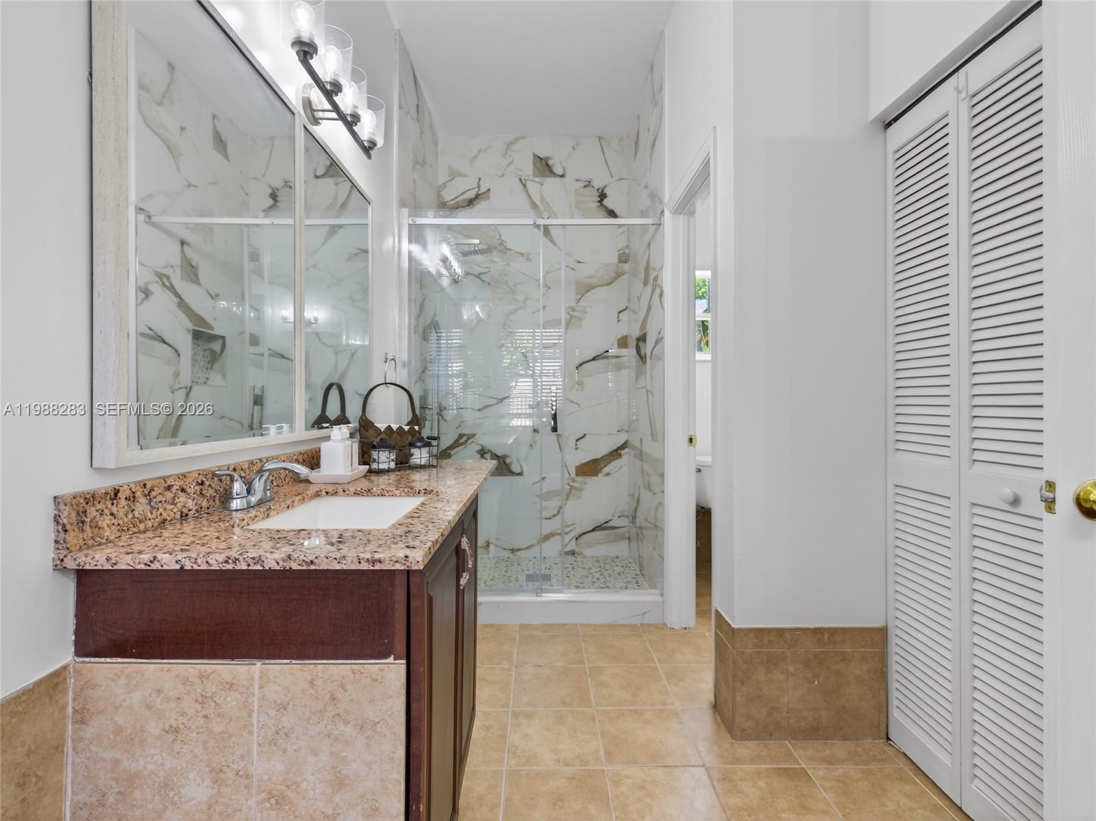 4317 Willow Ridge Drive Weston, FL 33331 - Photo 21 of 71 a bathroom with a granite countertop sink a mirror and shower